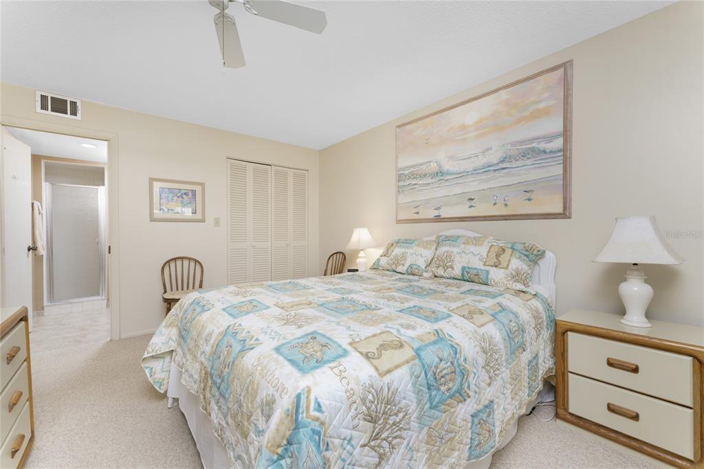 2700 North Beach Road, Unit E107 Englewood, FL 34223 - Photo 25 of 62 a bedroom with a bed and a painting on the wall