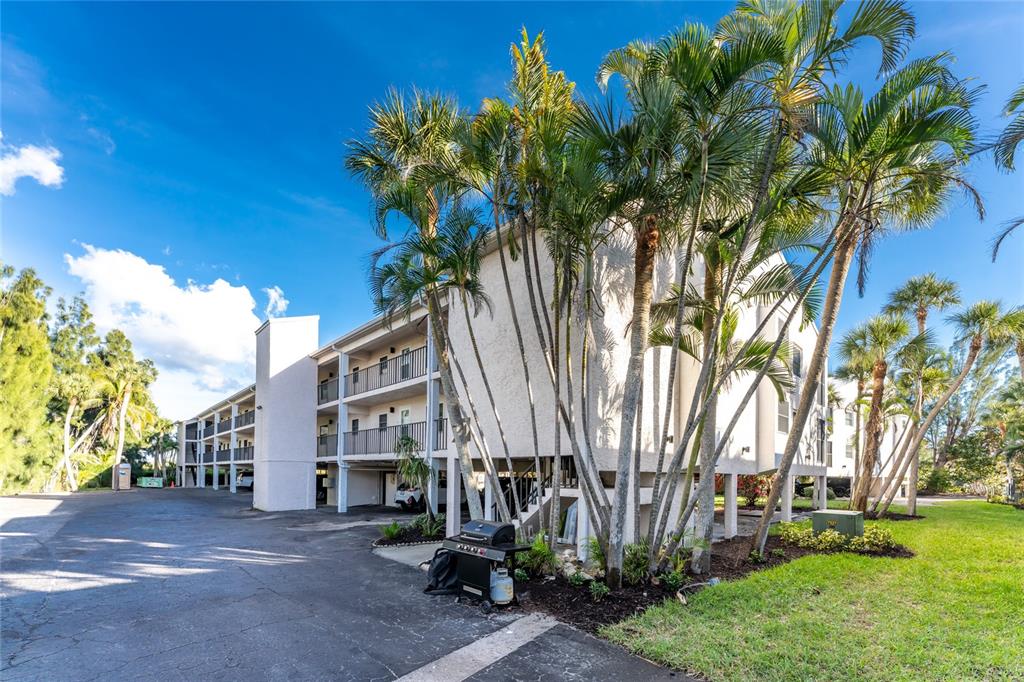 2700 North Beach Road, Unit E107 Englewood, FL 34223 - Photo 41 of 62 a view of a street with a building and a palm tree