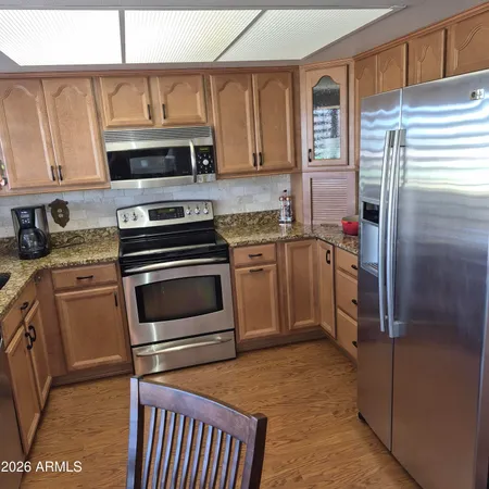 a kitchen with stainless steel appliances granite countertop a stove a refrigerator and a microwave