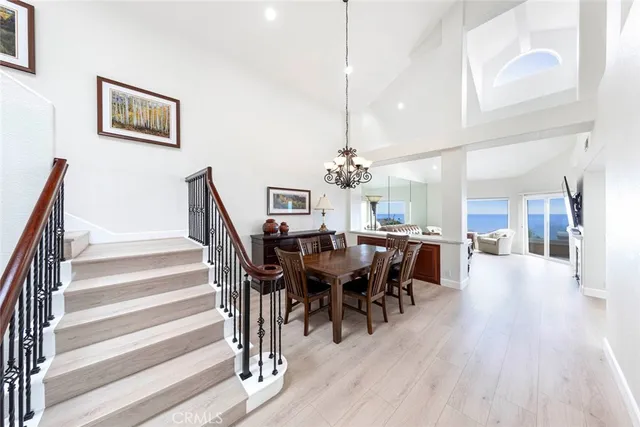 a view of a dining room with furniture a chandelier and wooden floor