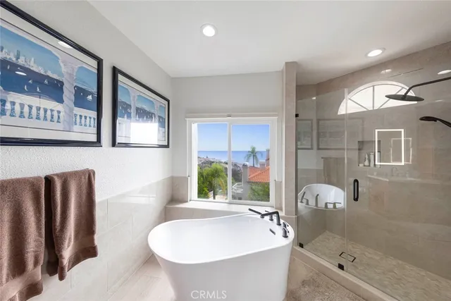 a spacious bathroom with a tub double sink and mirror