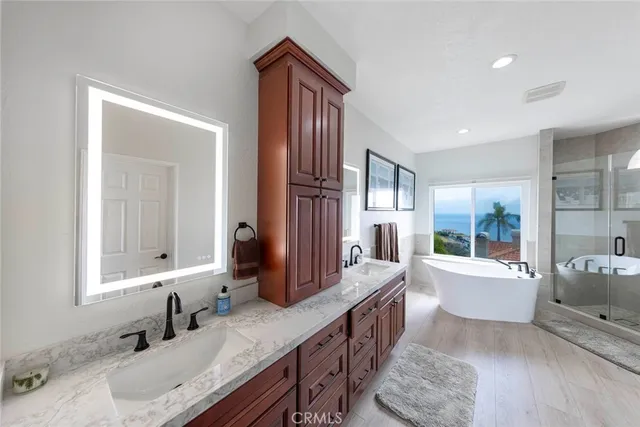a spacious bathroom with a tub double sink and mirror