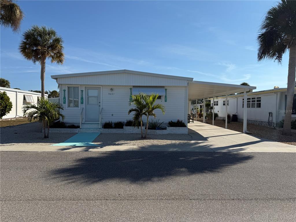 a view of a house with potted plants and palm trees