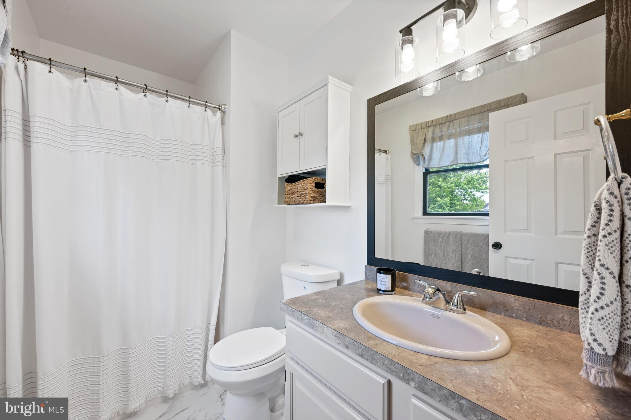 329 Hunter Path Road Hummelstown, PA 17036 - Photo 15 of 37 a bathroom with a granite countertop sink toilet a mirror a vanity and shower