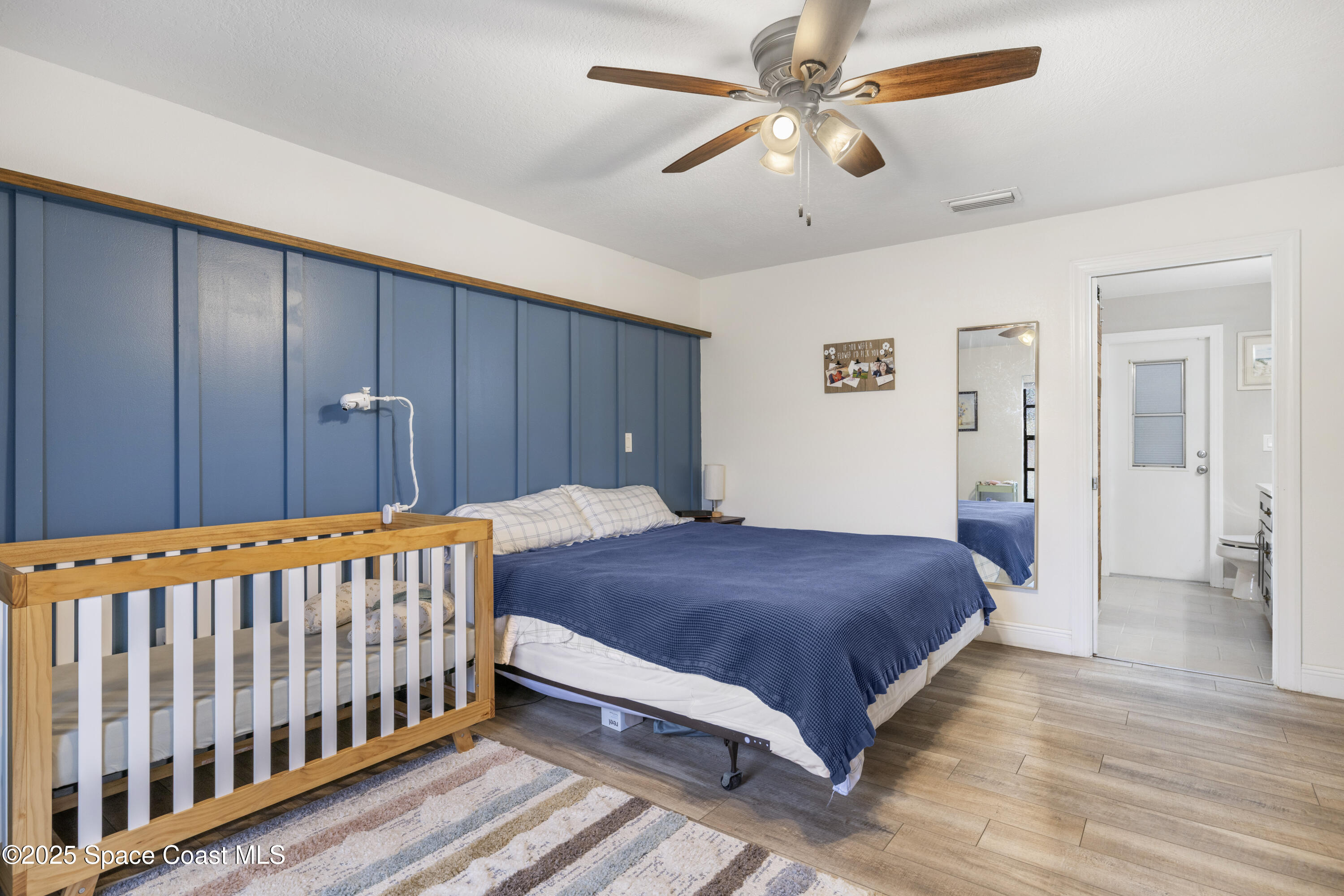 456 Narragansett Street Northeast Palm Bay, FL 32907 - Photo 23 of 43 a bedroom with a large bed and a chandelier