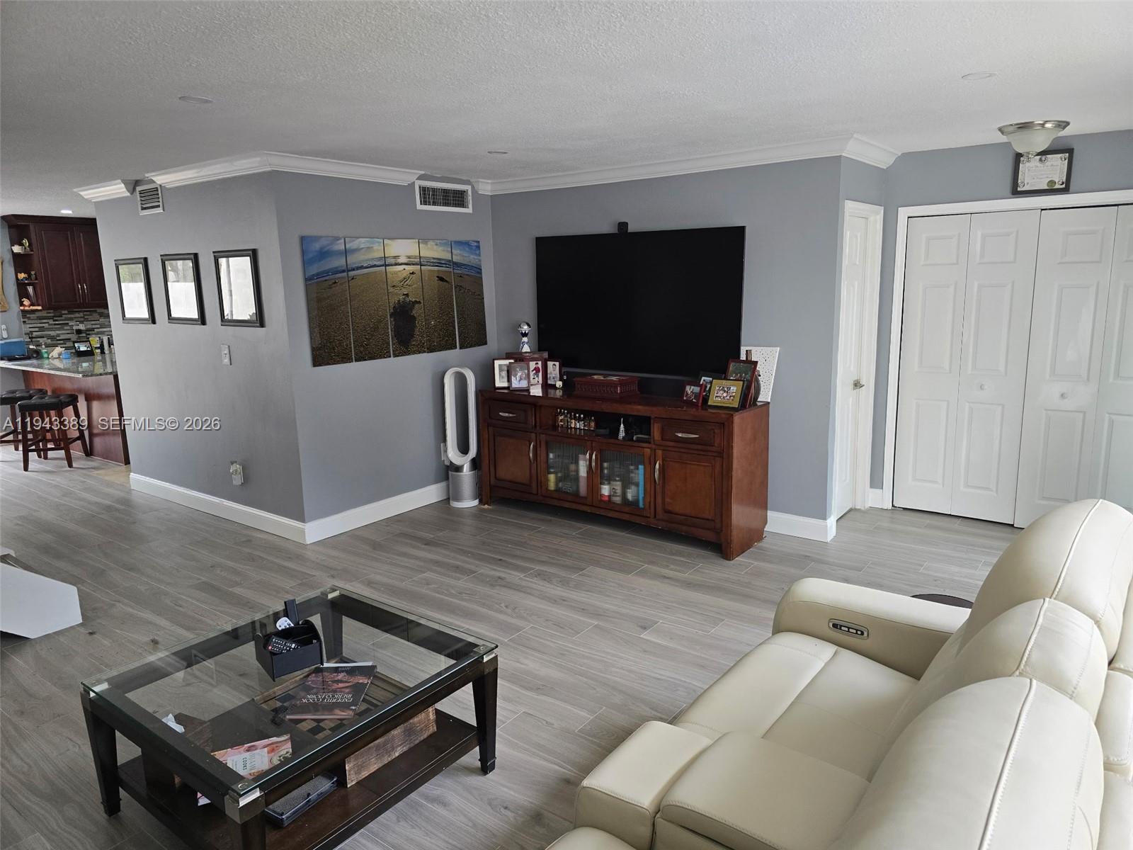 7753 Southwest 102nd Place Miami, FL 33173 - Photo 2 of 18 a living room with furniture and a flat screen tv