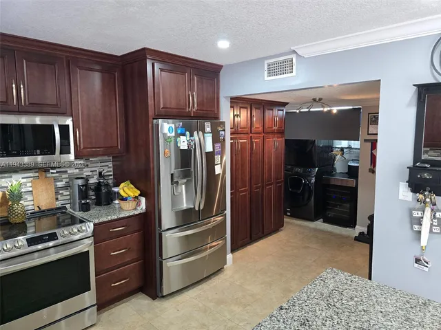 a kitchen with stainless steel appliances granite countertop a refrigerator stove and cabinets
