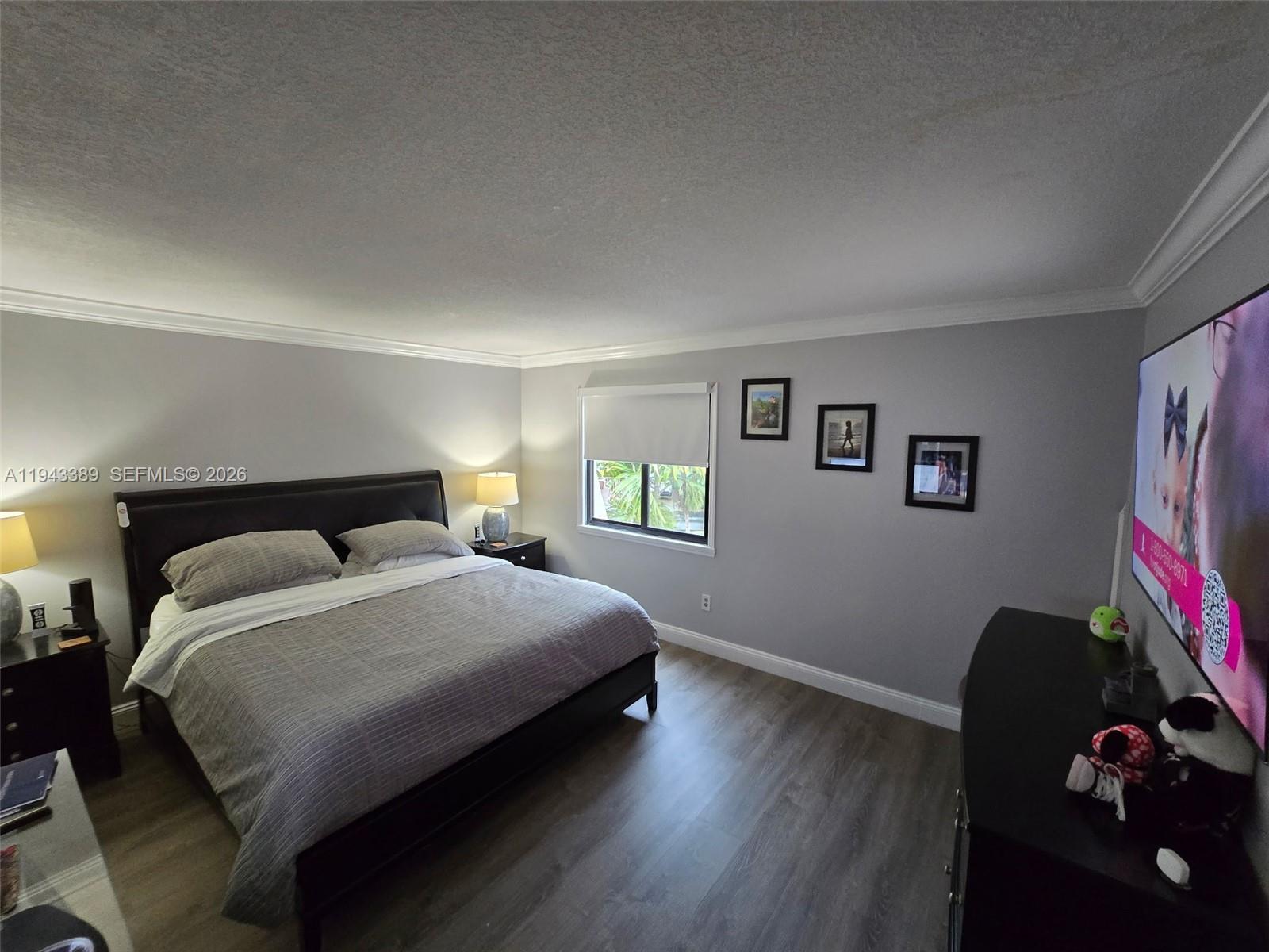 7753 Southwest 102nd Place Miami, FL 33173 - Photo 7 of 18 a bedroom with a bed and wooden floor