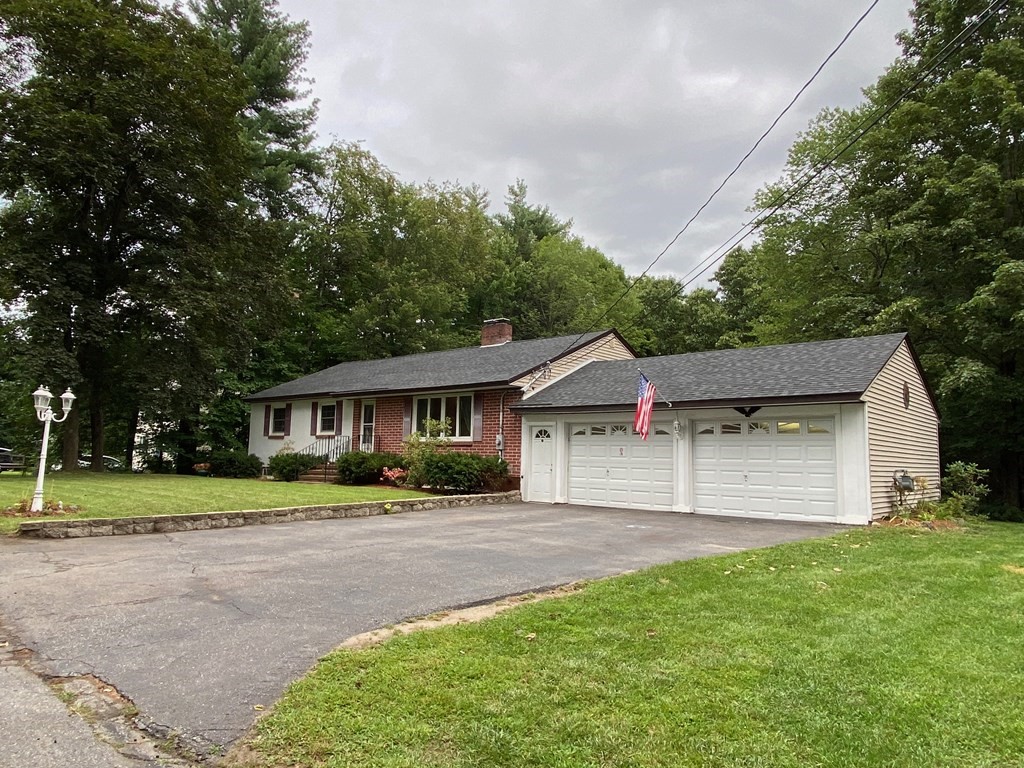 a front view of a house with a yard and trees