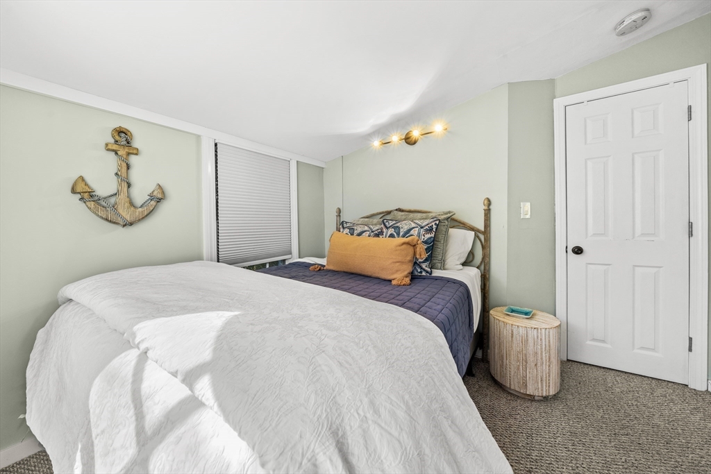 9 Gingerbread Hill, Unit 1 Marblehead, MA 01945 - Photo 13 of 16 a bedroom with a bed and a painting on the wall