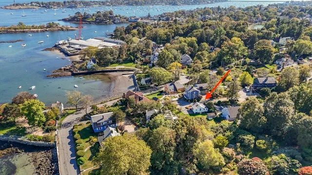 an aerial view of a house with a yard and lake view