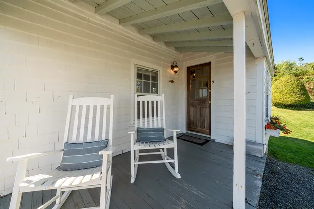 a view of front door with chair and wooden floor
