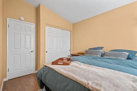 a bedroom with a bed and wooden floor