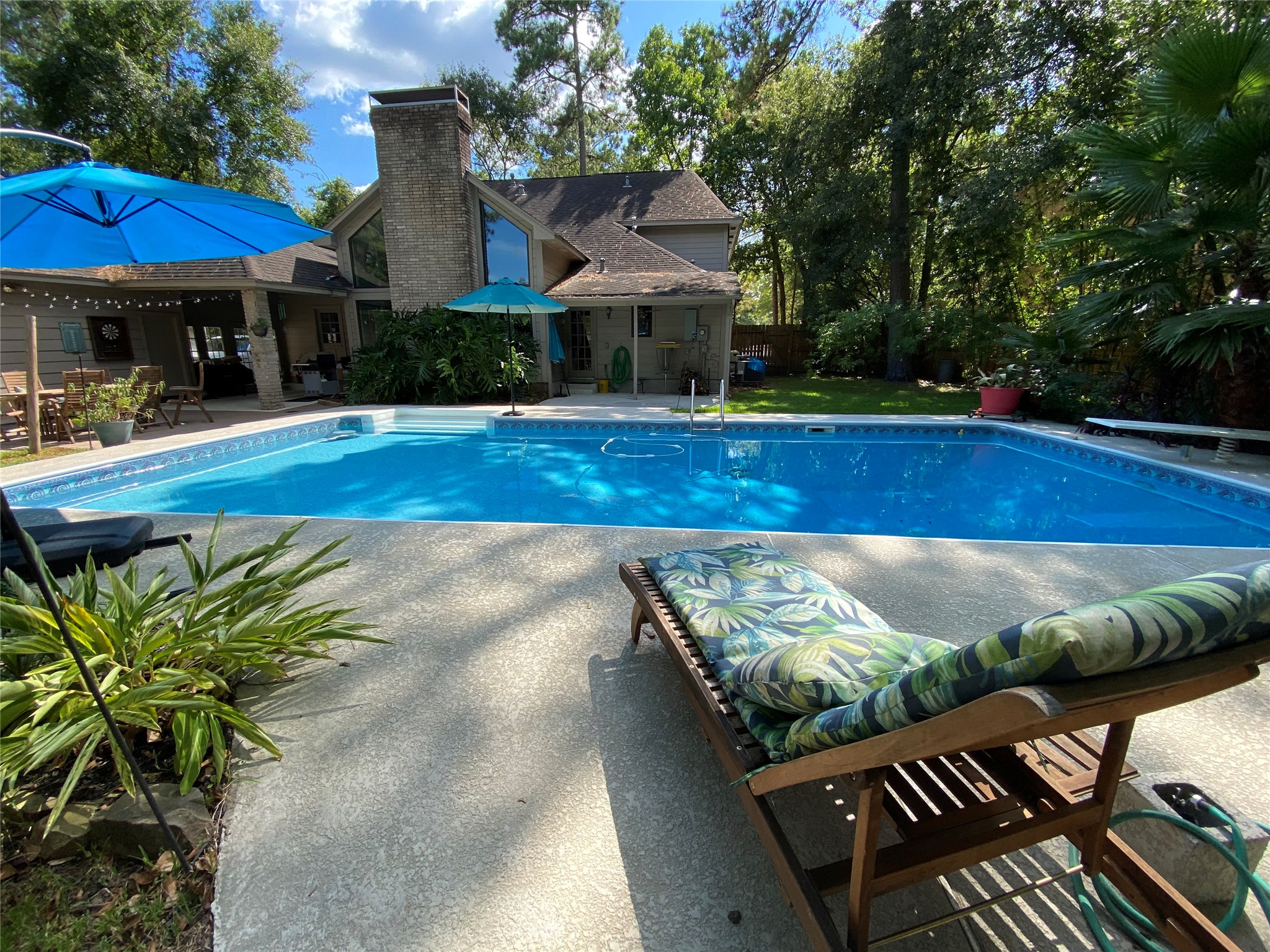 a view of house with swimming pool and outdoor seating