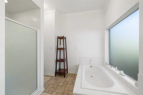 a spacious bedroom with a large bed and a chandelier