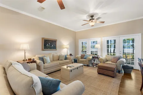 a view of a dining room and livingroom with furniture wooden floor a rug and a chandelier