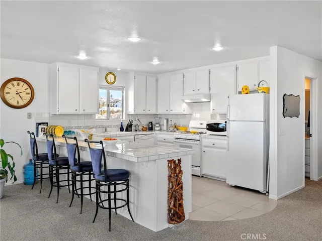 a kitchen with a refrigerator and white cabinets