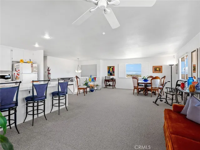 a living room with furniture and a dining table with wooden floor