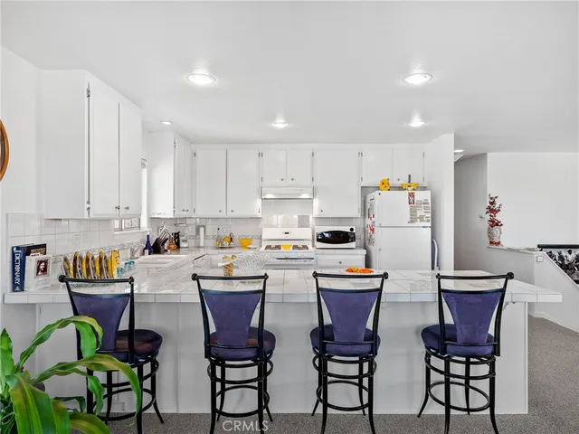 a kitchen with stainless steel appliances a table chairs and a refrigerator