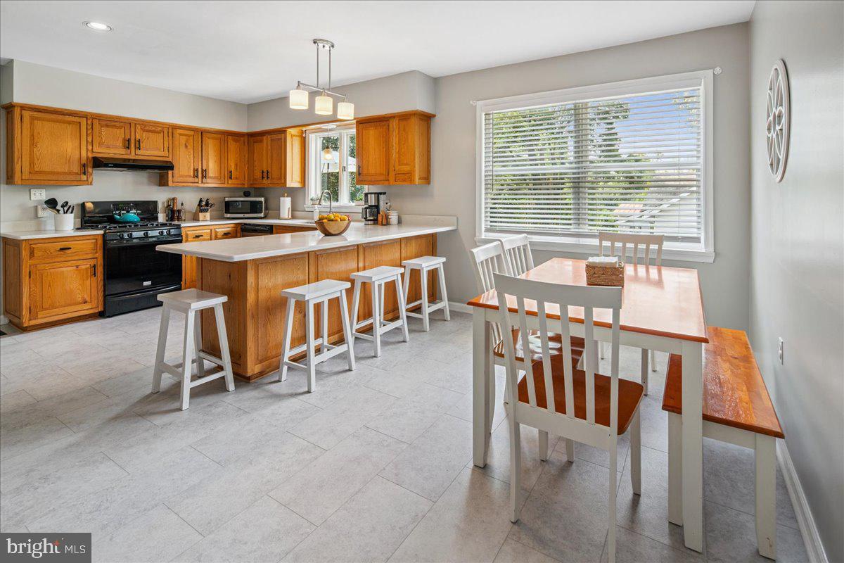 8 High Acres Drive Ewing, NJ 08628 - Photo 16 of 43 a kitchen with kitchen island granite countertop a stove a sink a dining table and chairs