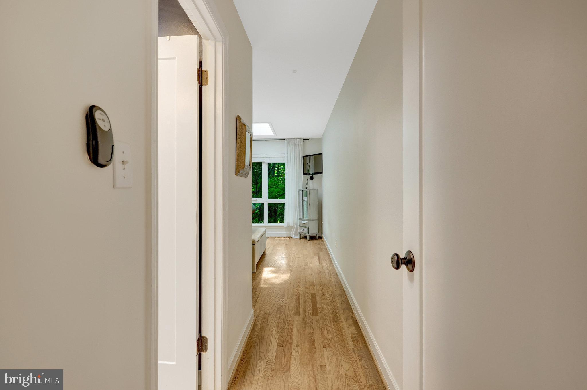 11712 Indian Ridge Road Reston, VA 20191 - Photo 58 of 77 a view of a hallway with wooden floor and a bathroom