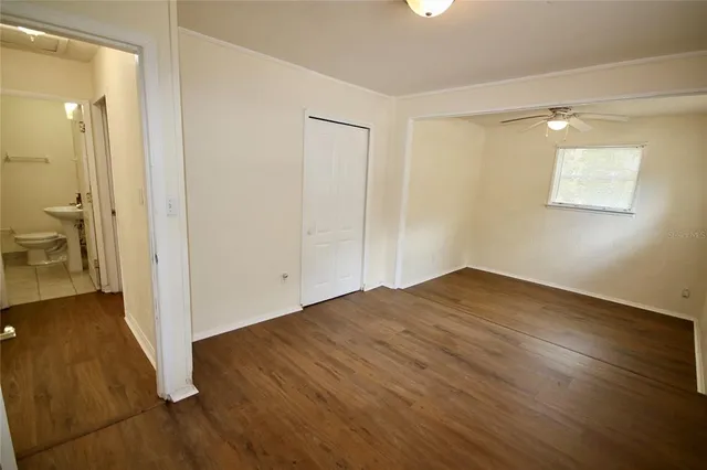 an empty room with wooden floor and a bathroom
