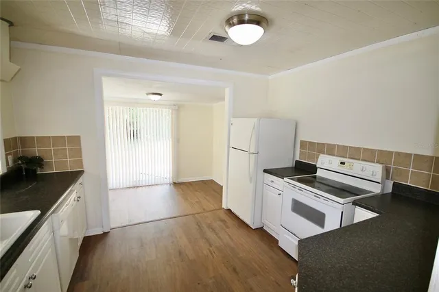 a kitchen with granite countertop a stove and a refrigerator