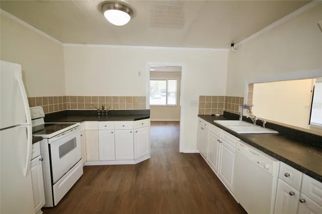 a kitchen with granite countertop white cabinets and white appliances