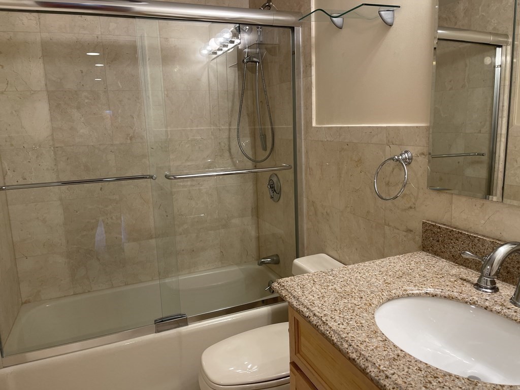 20 Webster Street, Unit 405 Brookline, MA 02446 - Photo 9 of 22 a bathroom with a granite countertop shower sink vanity and toilet
