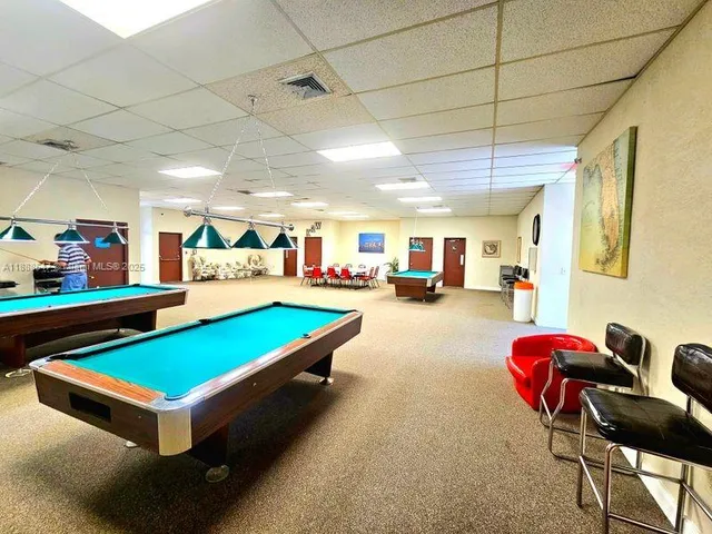 a room with pool table and windows