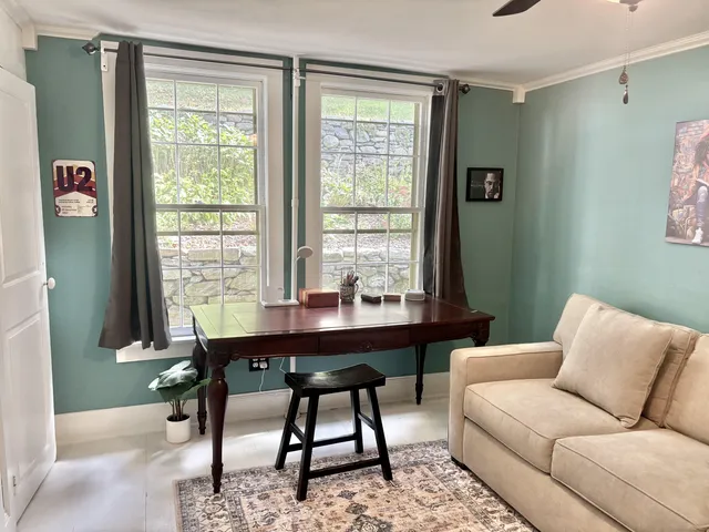 a work room with furniture wooden floor and a window