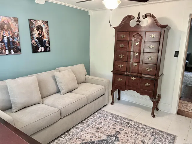 a living room with furniture a rug and a wall painting