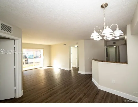 a view of a room with wooden floor and large windows