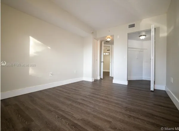 a view of an empty room and wooden floor