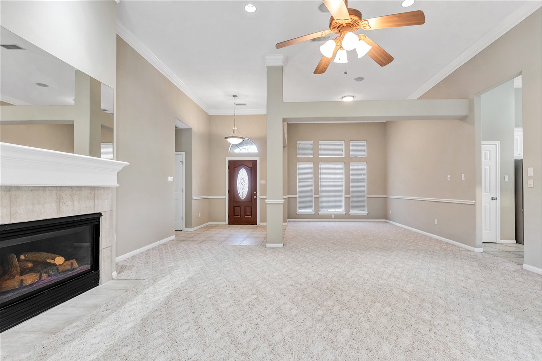 1602 Leopard Court College Station, TX 77840 - Photo 15 of 28 a view of an empty room with chandelier fan and fire place