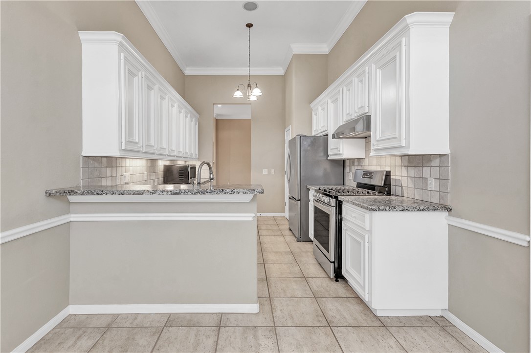 1602 Leopard Court College Station, TX 77840 - Photo 5 of 28 a kitchen with stainless steel appliances granite countertop a stove a sink and a refrigerator