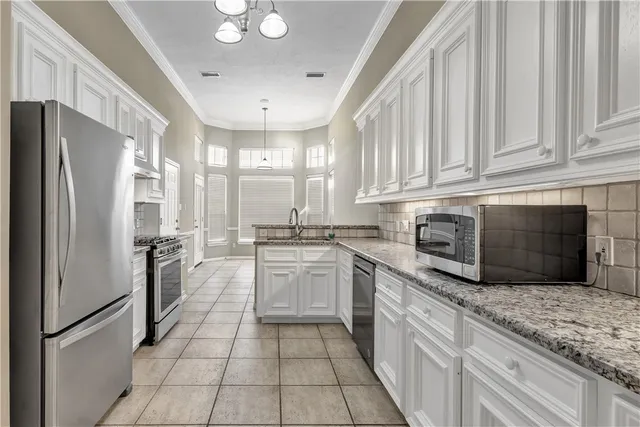 a kitchen with stainless steel appliances granite countertop a refrigerator sink and stove