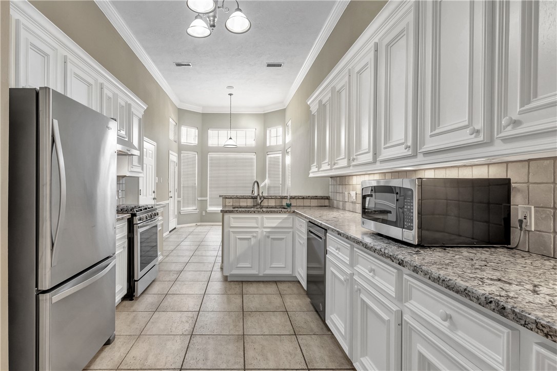 1602 Leopard Court College Station, TX 77840 - Photo 6 of 28 a kitchen with stainless steel appliances granite countertop a refrigerator sink and stove