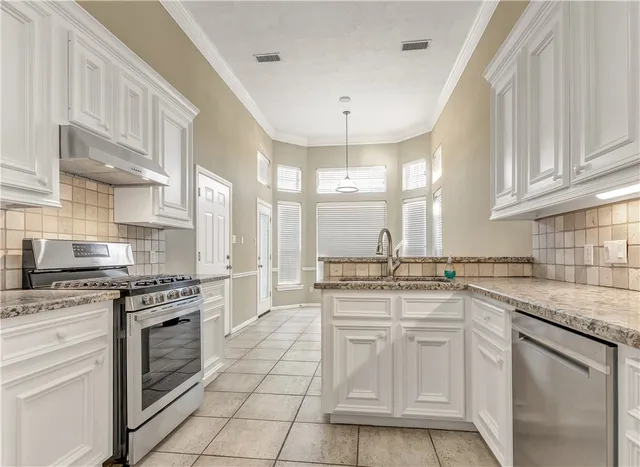 a kitchen with a stove top oven sink and cabinets