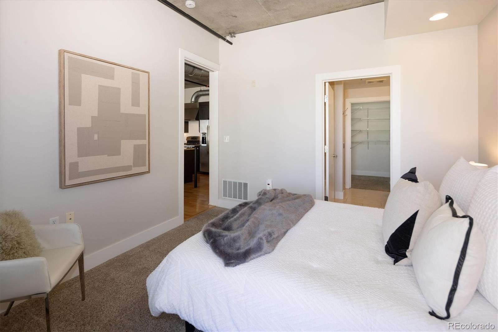 2210 Blake Street, Unit 209 Denver, CO 80205 - Photo 23 of 33 a bedroom with a bed and a chair
