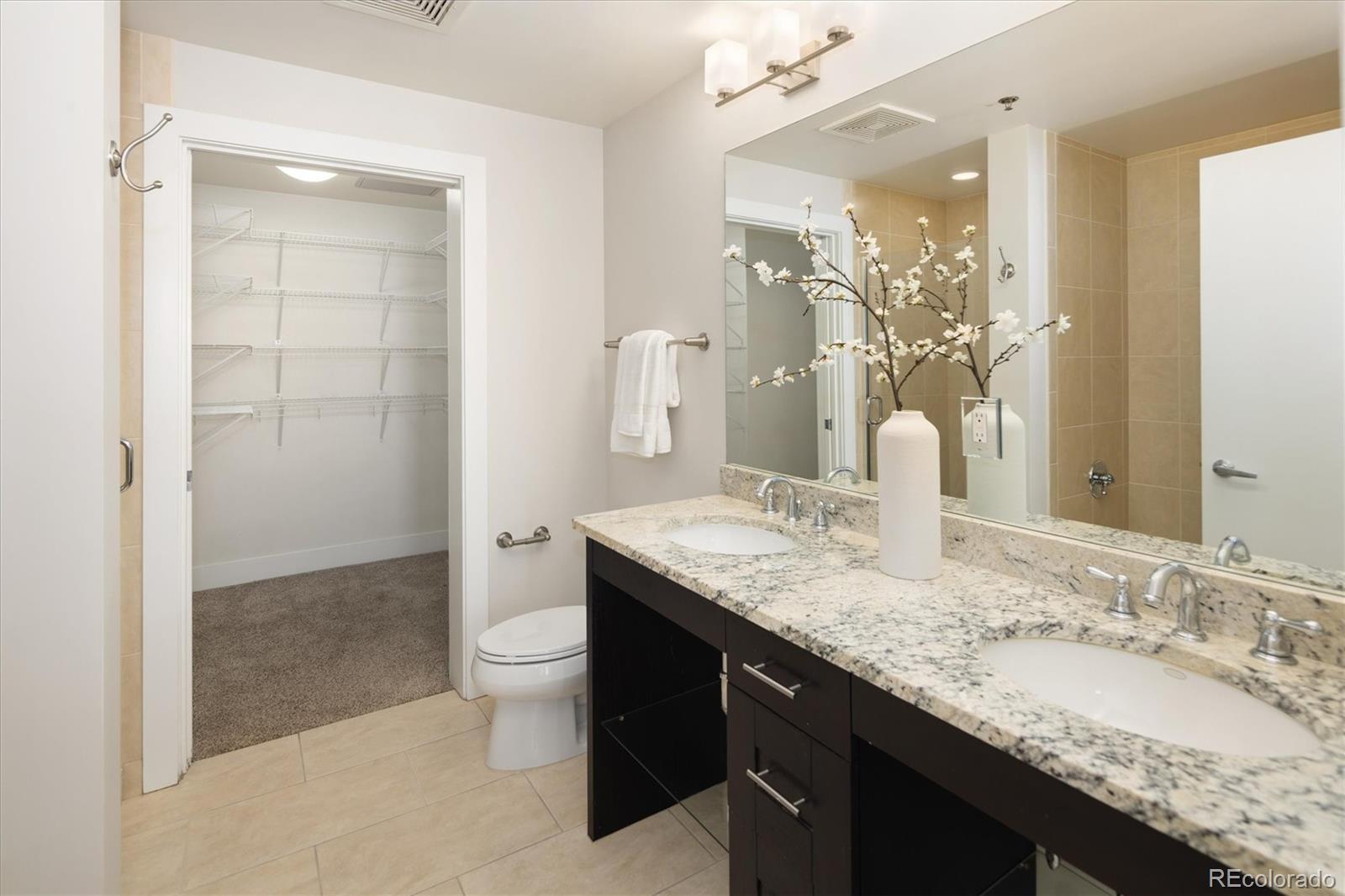 2210 Blake Street, Unit 209 Denver, CO 80205 - Photo 24 of 33 a bathroom with a granite countertop sink a toilet and shower