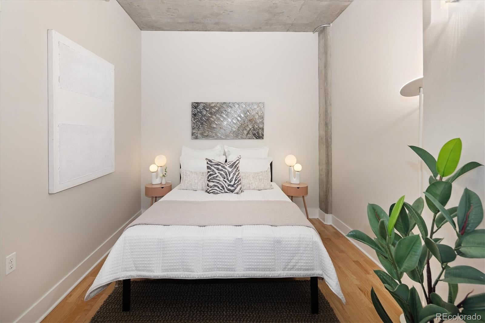 2210 Blake Street, Unit 209 Denver, CO 80205 - Photo 28 of 33 a bedroom with a bed table and a potted plant