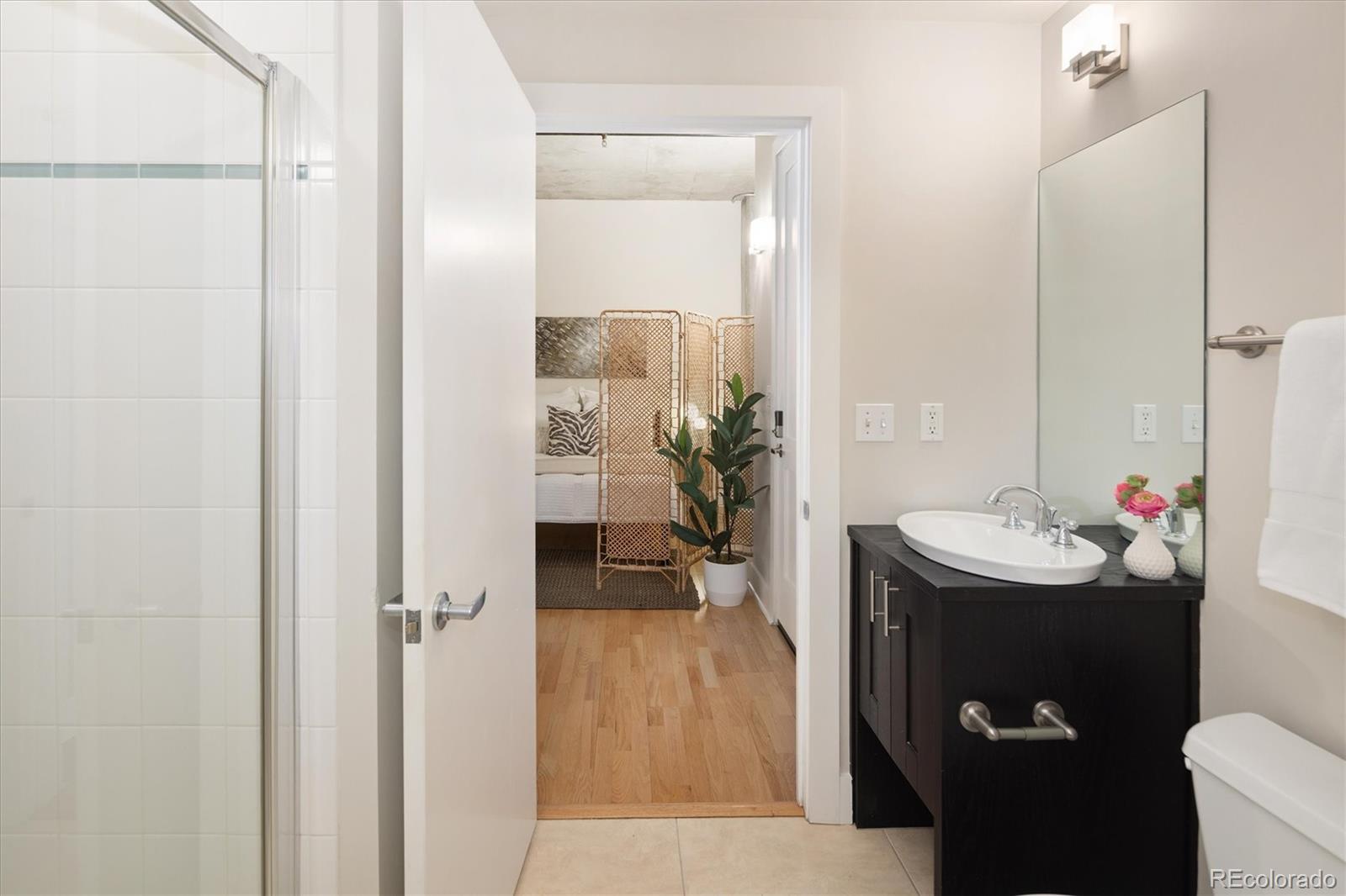2210 Blake Street, Unit 209 Denver, CO 80205 - Photo 29 of 33 a bathroom with a sink and mirror with toilet