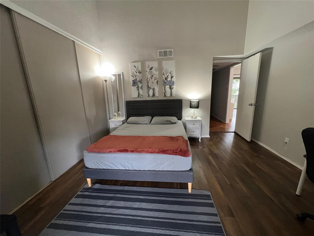 4569 North O'Connor Road, Unit 2318 Irving, TX 75062 - Photo 7 of 9 a bedroom with a bed and wooden floor