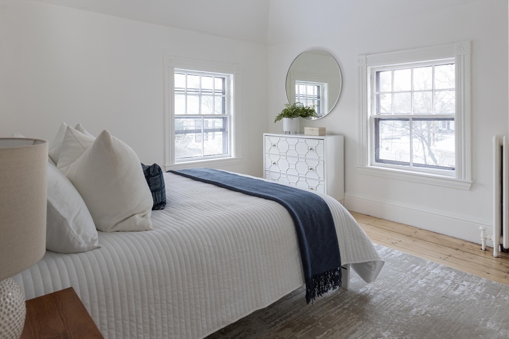 61 Toxteth Street Brookline, MA 02446 - Photo 15 of 21 a bedroom with a bed windows and a chandelier