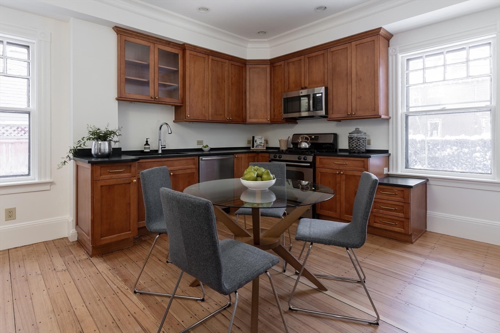61 Toxteth Street Brookline, MA 02446 - Photo 9 of 21 a kitchen with stainless steel appliances granite countertop wooden floors a stove top oven a sink dishwasher and cabinets with wooden floor
