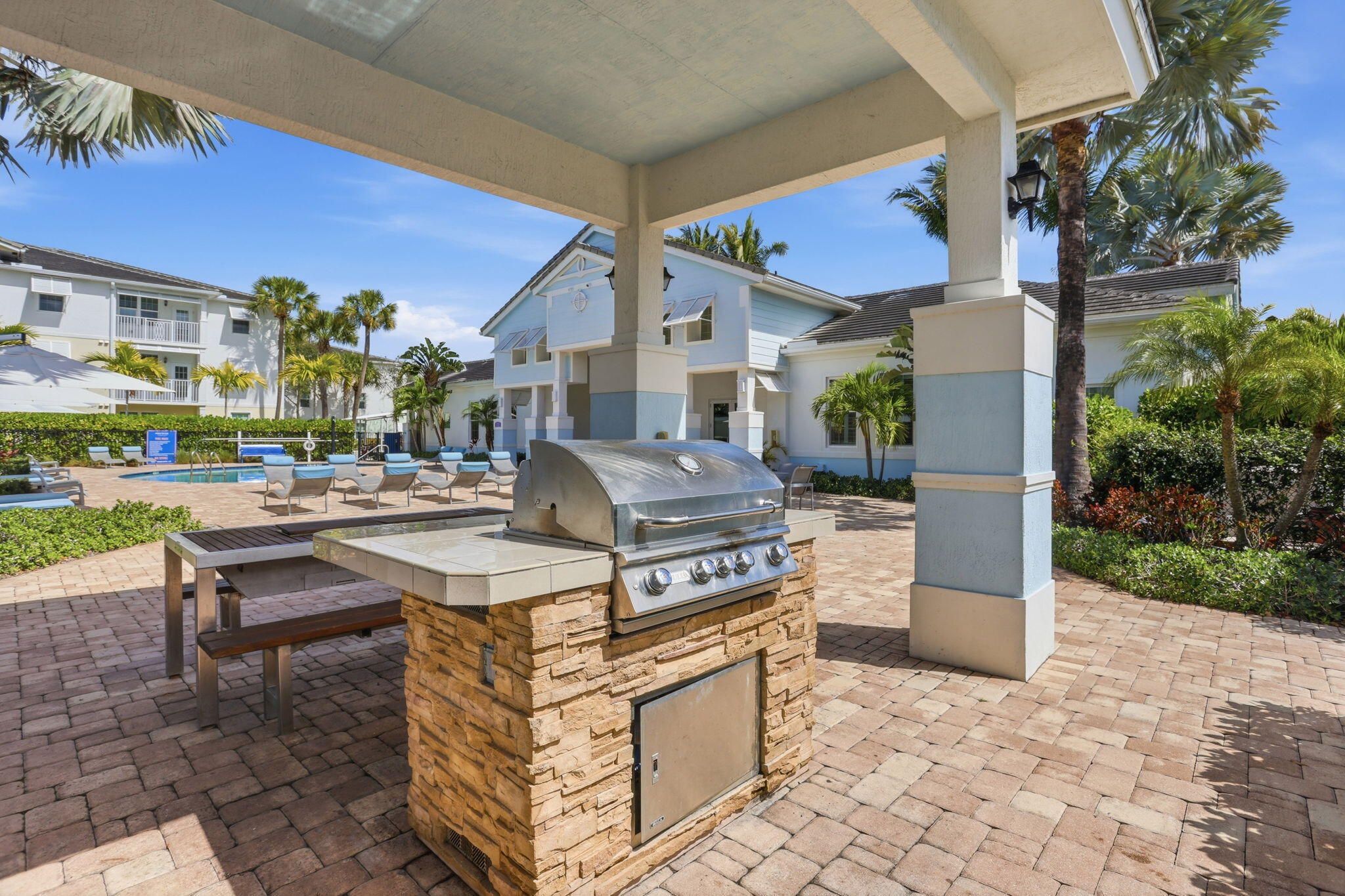 3613 High Ridge Road, Unit 304 Boynton Beach, FL 33426 - Photo 27 of 32 a view of a patio with dining table and chairs under an umbrella