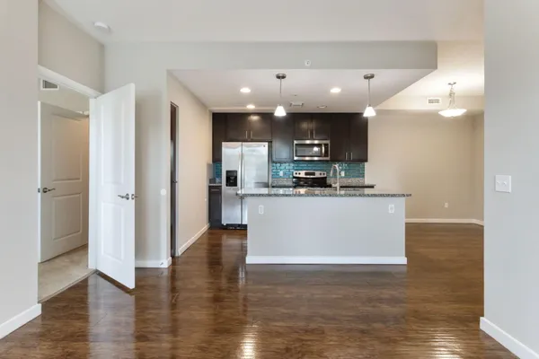 a view of kitchen with kitchen island and stainless steel appliances