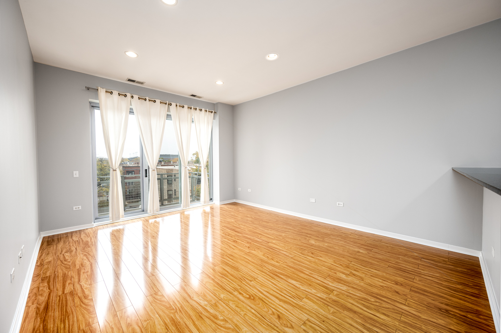 3920 North Sheridan Road, Unit 406 Chicago, IL 60613 - Photo 2 of 12 a view of an empty room with wooden floor and windows