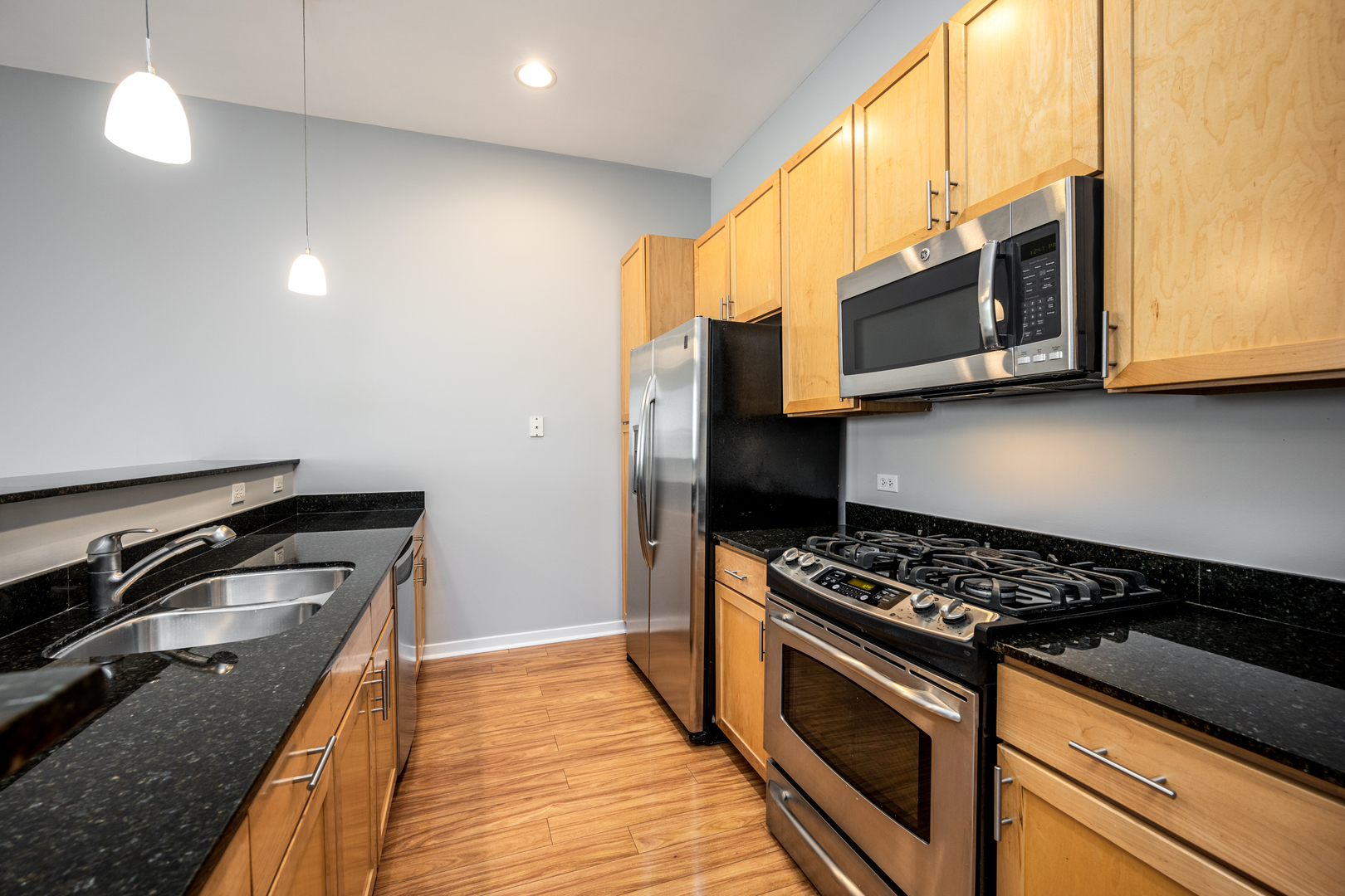 3920 North Sheridan Road, Unit 406 Chicago, IL 60613 - Photo 4 of 12 a kitchen with stainless steel appliances granite countertop a stove a microwave and a sink